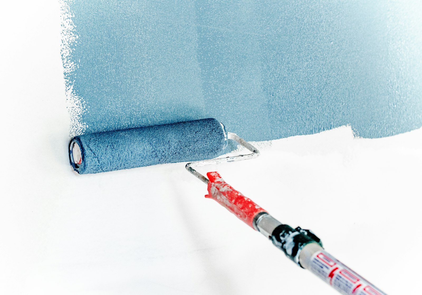 Painter applying a coat of paint to an interior wall